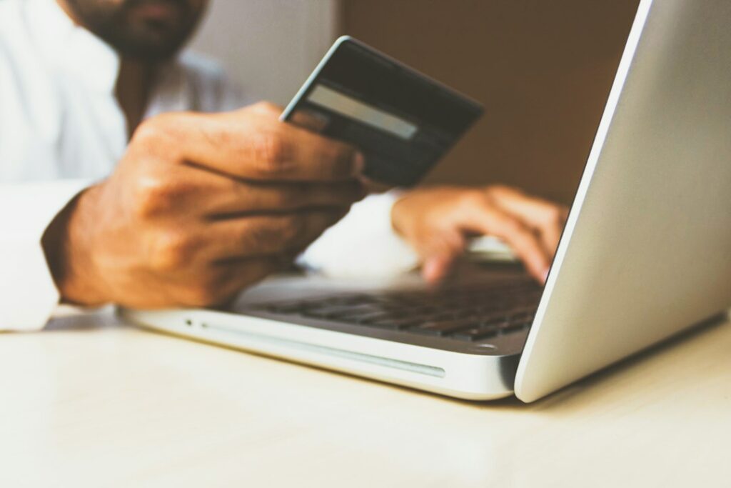 Pessoa usando cartão e notebook em uma compra online